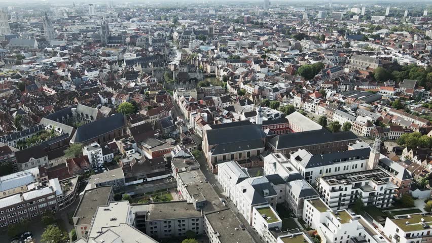 Aerial view of Gravensteen castle surrounded by waterways, with historic buildings in the background, Ghent, Flanders, Belgium.