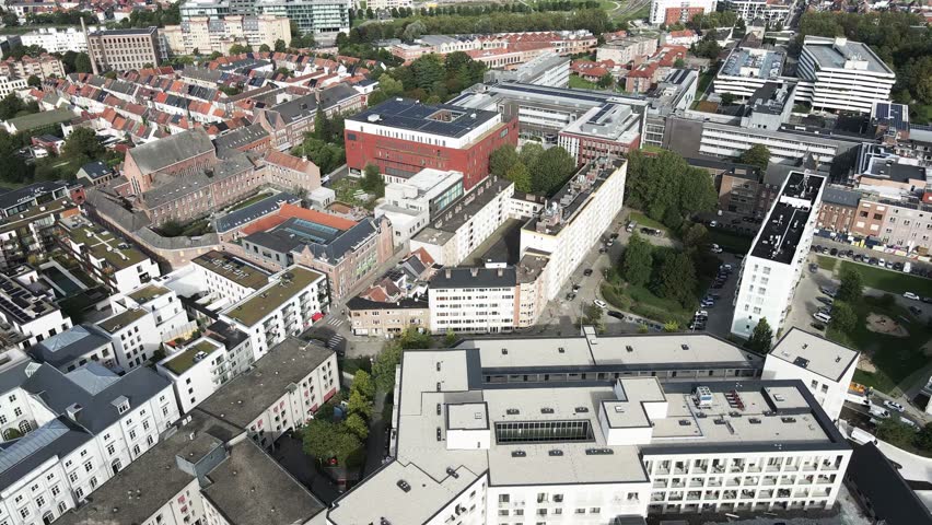 Aerial view of buildings and rooftops, a mix of modern and historic architecture, creating a vibrant tapestry of urban life, Ghent, Flanders, Belgium.