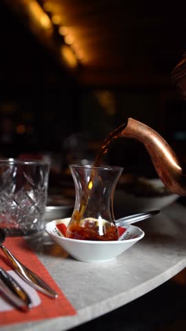 Traditional Turkish tea being poured into a glass, vertical, 9:16 reels story format.