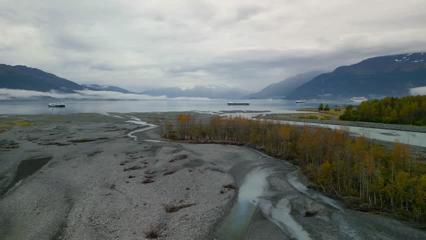 Aerial view of scenic Port Valdez in Alaska with dramatic sky during cloudy autumn day.