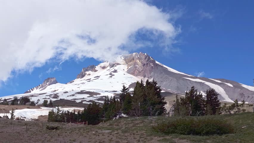 Stunning transformation of Mount Hood as clouds drift in, creating a mystical ambiance above the snowcapped peak near Timberline Lodge, Government Camp, Oregon