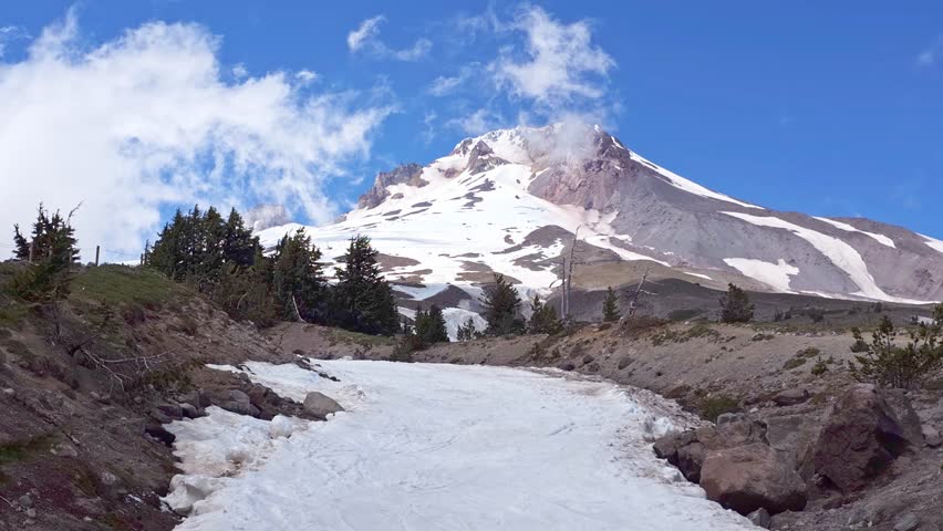 Stunning transformation of Mount Hood as clouds drift in, creating a mystical ambiance above the snowcapped peak near Timberline Lodge, Government Camp, Oregon