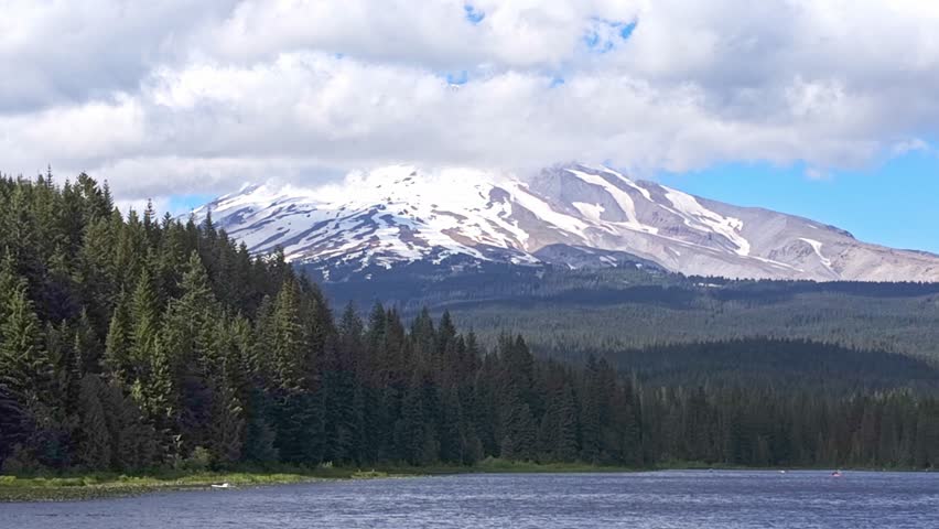 Beautiful view of snowcapped Mount Hood over Trillium Lake on a sunny day with clouds covering the peak, Government Camp, Oregon