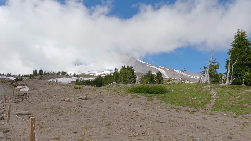 Stunning transformation of Mount Hood as clouds drift in, creating a mystical ambiance above the snowcapped peak near Timberline Lodge, Government Camp, Oregon