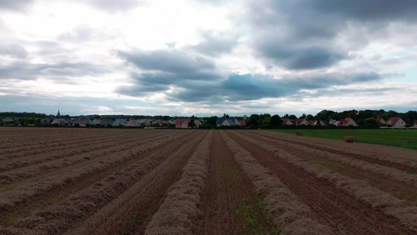 Dramatic sky over rural farmland: clouds and landscape transformation.