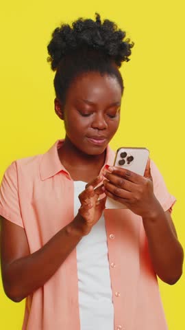 Happy excited African Black woman girl use smartphone typing browsing shouting say wow yes found out great big win good news lottery goal achievement celebrating success, winning play game on yellow