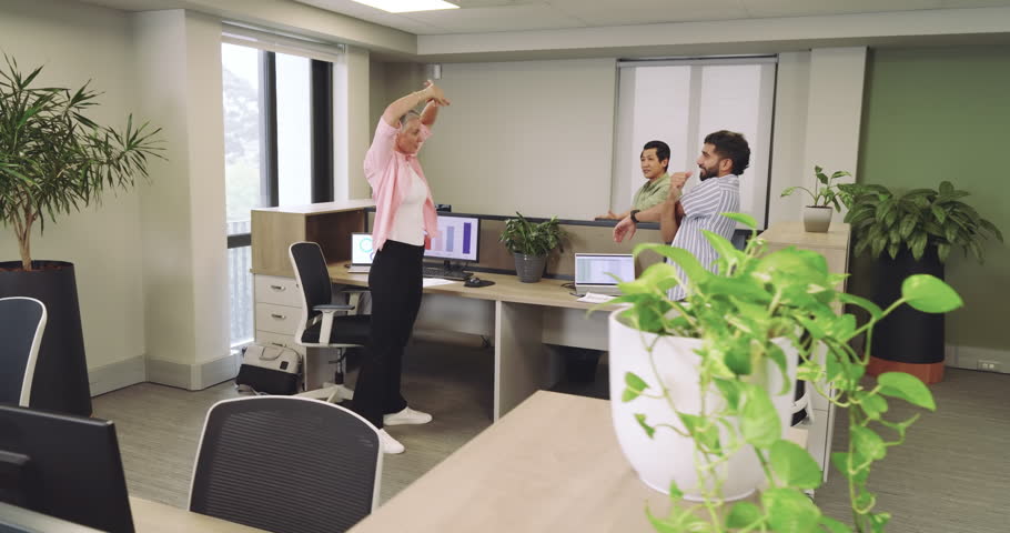 Diverse coworkers starting workday with stretching, high-fiving, discussing data at workstation. Collaboration, teamwork, productivity, modern, vibrant, professional, ergonomic