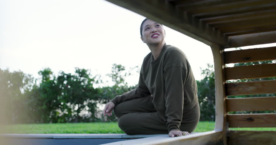 Lens shifting pergola capturing Asian woman kneeling pool turning head viewing mountains copy space. Outdoor, relaxation, serenity, landscape, leisure, minimalist, wellness