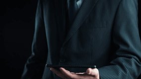 A businessman in a formal suit holds a smartphone displaying stock market trends and growth indicators, symbolizing financial success and technology advancement. Qubit - Powered by Shutterstock - Get 15% off with code: PIKWIZARD15