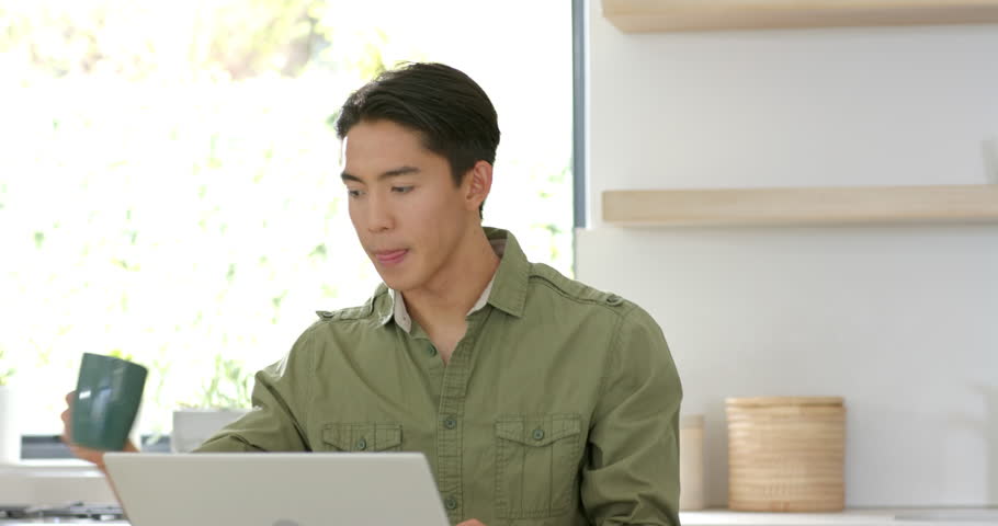 Fixing posture, Asian man typing on laptop in home workspace noting ideas for planning, copy space. Concentration, productivity, minimalist, modern, homeoffice, focus, reflection