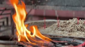 Candle flame burning in bowl with melted wax at temple, warm and spiritual atmosphere. - Powered by Shutterstock - Get 15% off with code: PIKWIZARD15
