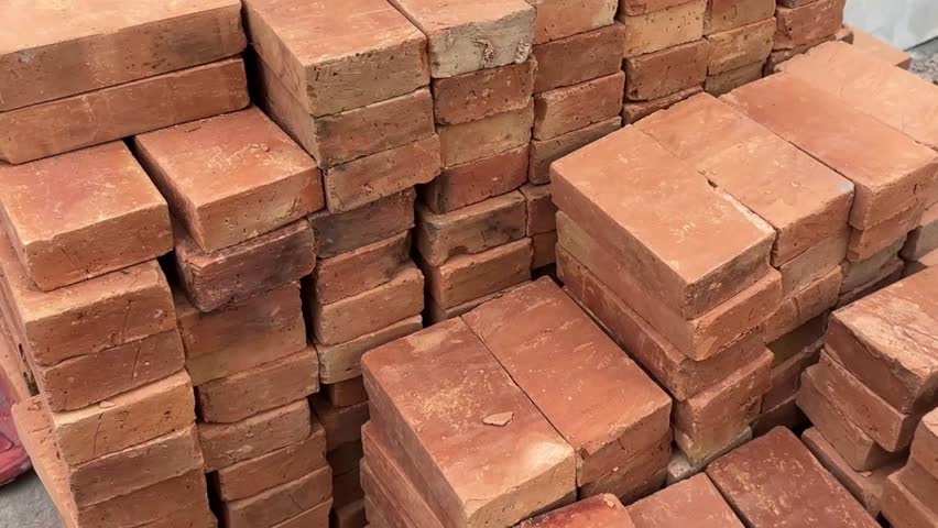 Stack of orange bricks arranged in rows with rough texture and construction detail.