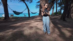 Slow motion video of young woman walking along the beach holding a phone under the shade of a pine tree by the sea.A large tunnel of pine trees along the beach catches the eye
beautiful natural place - Powered by Shutterstock - Get 15% off with code: PIKWIZARD15
