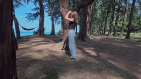 Slow motion video of young woman walking along the beach holding a phone under the shade of a pine tree by the sea.A large tunnel of pine trees along the beach catches the eye
beautiful natural place - Powered by Shutterstock - Get 15% off with code: PIKWIZARD15