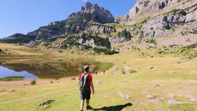 Solo male hiker walking along a mountain trail in Aragon, heading toward the glacial Ibón de Piedrafita with panoramic views over the Pyrenees and the rugged beauty of the Tena Valley

 - Powered by Shutterstock - Get 15% off with code: PIKWIZARD15