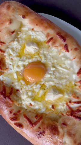 Top view of tasty Khachapuri in Adjarian style with egg close up