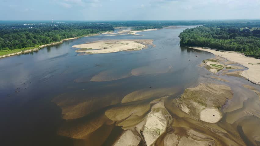A drone view of the wild Vistula River near Warsaw, Poland, showcasing sandbanks, low water levels, and untouched natural landscapes