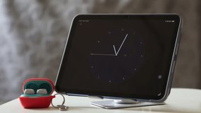 A modern tablet showing a clock interface alongside wireless earbuds, symbolizing technology and connectivity. - Powered by Shutterstock - Get 15% off with code: PIKWIZARD15