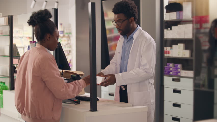 African American man pharmacist assist customer in pharmacy medicine prescription customer woman buying pills healthy medication vitamins drugs shopping pharmaceutics order help sickness treatment