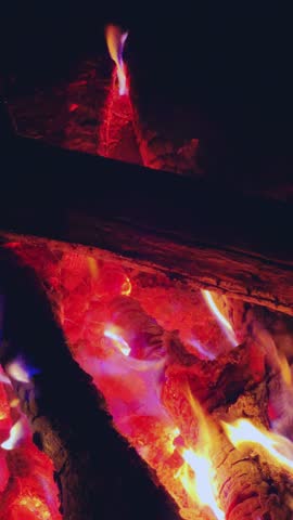 Astrakhan Region,Russia: A campfire on a sandy beach on the banks of the Volga River. A burning campfire on the banks of the Volga River in complete darkness. Sparks from the campfire, flames at night