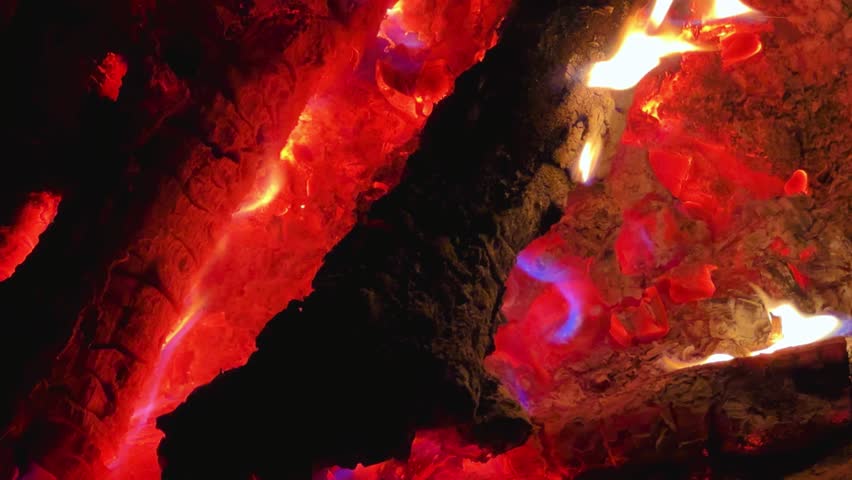 Astrakhan Region,Russia: A campfire on a sandy beach on the banks of the Volga River. A burning campfire on the banks of the Volga River in complete darkness. Sparks from the campfire, flames at night