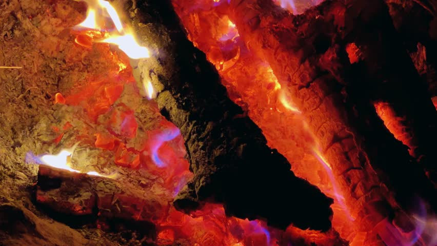 Astrakhan Region,Russia: A campfire on a sandy beach on the banks of the Volga River. A burning campfire on the banks of the Volga River in complete darkness. Sparks from the campfire, flames at night