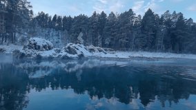 Tranquil snowy forest lakeside with gentle ripples reflecting pine trees at sunrise. - Powered by Shutterstock - Get 15% off with code: PIKWIZARD15