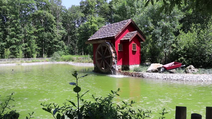 Red watermill on the shore of the lake