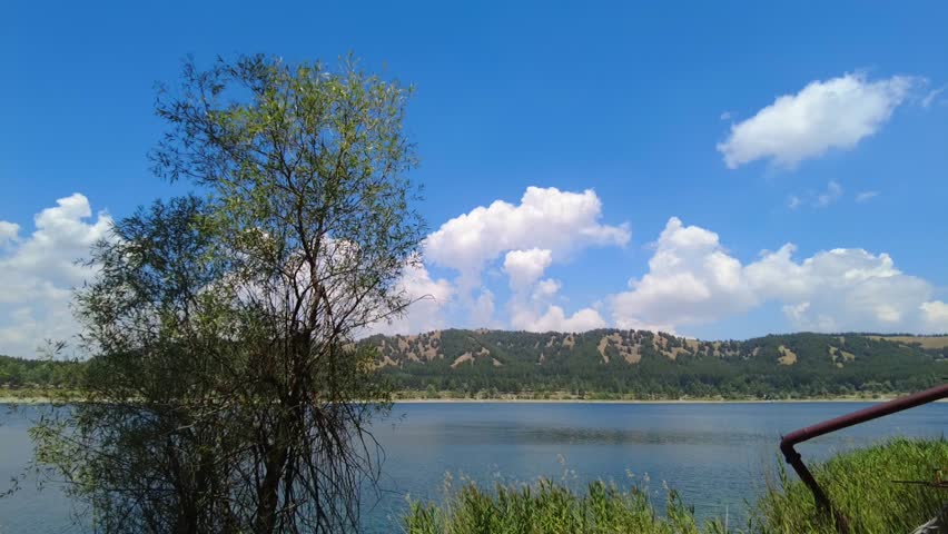 Watching the clouds on the shore of a mountain lake on a summer day during my vacation.