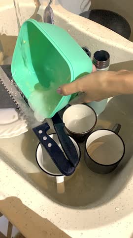 Dirty dishes piled in a sink under running water, waiting to be washed. Perfect for illustrating home chores, daily routine, or cleaning tutorials