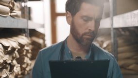 Close up focused Caucasian businessman coffee factory worker small business owner man male holding clipboard write pen check inventory aroma supplies controls storage beans production stock checklist - Powered by Shutterstock - Get 15% off with code: PIKWIZARD15