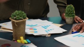 Multiethnic forecasting team reviewing report files during important meeting, updating project agenda and discussing business development with shareholders in office after hours. Camera B. - Powered by Shutterstock - Get 15% off with code: PIKWIZARD15