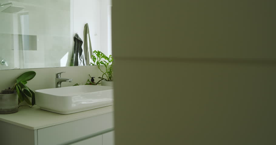 On recording start, camera is panning across bathroom to showcase plants, sinks, tub and shower. Minimalist, luxurious, natural, spa, elegant, calming, contemporary