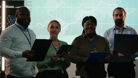 Portrait of employees team preparing a pitch for investors group meeting, working on ways to obtain more funds. Professional diverse colleagues address financial status after hours. Camera B. - Powered by Shutterstock - Get 15% off with code: PIKWIZARD15
