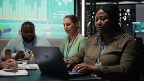 African american analyst and colleagues examining annual data reporting in a firm meeting at night, reviewing insight on laptop to facilitate global business development. Work team. Camera A. - Powered by Shutterstock - Get 15% off with code: PIKWIZARD15