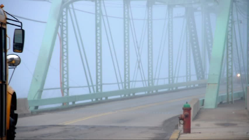Traffic passes over the Ambridge Bridge on a foggy morning.
