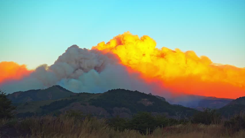Time-Lapse of a Catastrophic Wildfire with huge Smoke Plume at Sunset over the mountain forest in Lanín National Park, Argentina