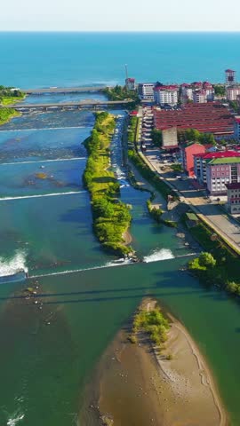 Vertical video. Ardeshen, Turkey. The place where the river flows into the Black Sea. Firtina River Valley. Sunny evening, Aerial View, Departure of the camera. Rich colors