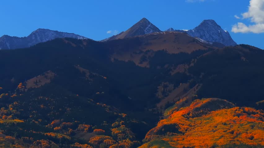 Fall Autumn sunny blue sky morning Aspen Capitol Peak Mount Snowmass aerial drone Colorado vibrant yellow orange White River National Forest snow dusting Rocky mountain peaks parallax circle right
