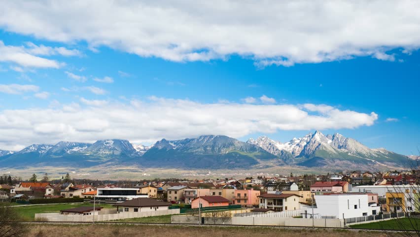 4K extreme wide shot time-lapse of High Tatras mountains from Poprad, Slovakia with drifting clouds, shifting light, and scenic village foreground—perfect for nature, travel, and landscape visuals.
