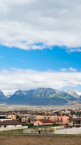4K portrait time-lapse of High Tatras mountains from Poprad, Slovakia with drifting clouds, shifting light, and scenic village foreground—perfect for nature, travel, and landscape visuals.