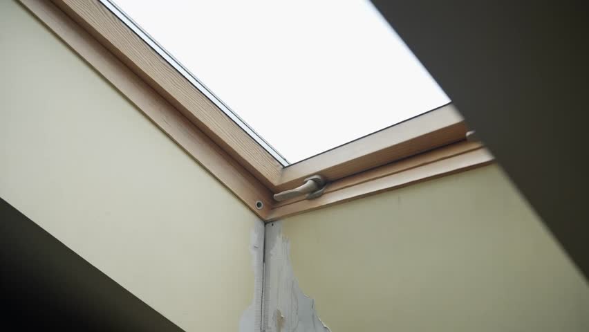 Rain leaking through ceiling window in a house during a storm