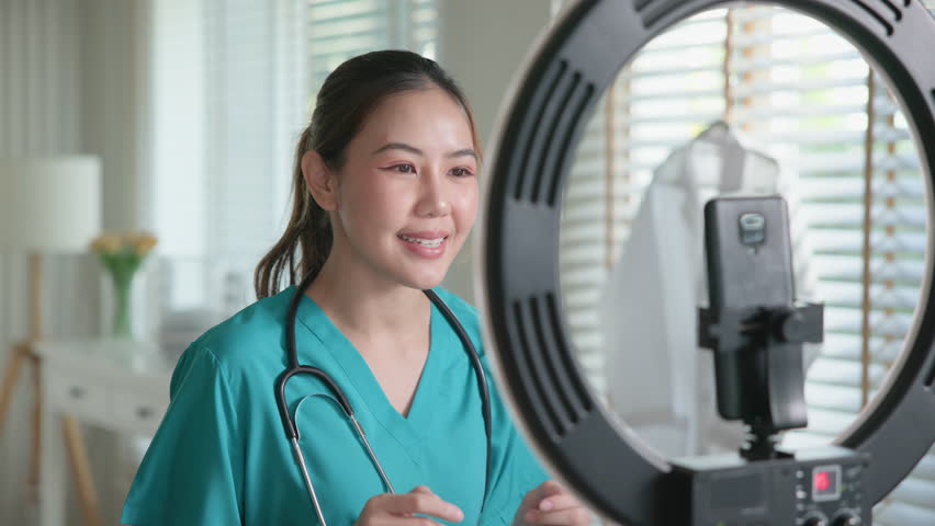 Young adult woman Gen Z asia people anti aging expert modern nurse live talk viral video selfie camera on mobile phone app mental health care. Online sharing digital virtual asian vlogger filming.
