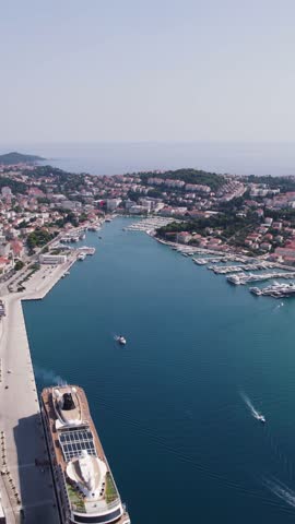 Aerial view of the modern Gruz Port in Dubrovnik, Croatia, showcasing the bustling maritime activity and coastal cityscape. vertical video