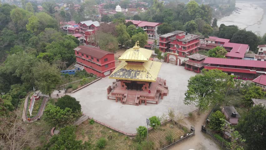 Drone footage gracefully circling Devdaha Temple in Chitwan, Nepal, showcasing sacred architecture and lush surroundings from all angles. Perfect for cultural, travel, and spiritual content.