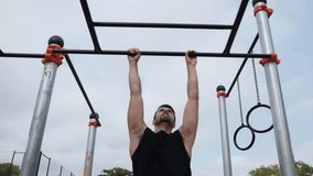 Determined athlete performing pull-ups on outdoor gymnastic equipment. Young sportsman exercising outdoors, demonstrating strength and fitness through pull-ups. Monkey bars.
 - Powered by Shutterstock - Get 15% off with code: PIKWIZARD15