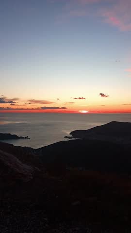 Sunset over the Adriatic Sea and Budva coastline, Montenegro: panoramic view from mountain viewpoint with colorful pink and blue sky, coastal slope and sea. A nature escape offering breathtaking views