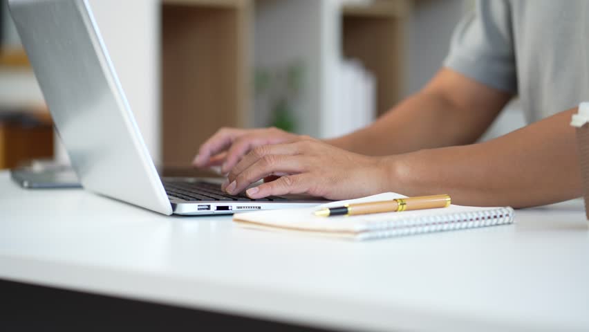 Young employee using computer working online, doing searching, taking notes, watching business training webinar in office, having virtual chat meeting looking at laptop at work. - Powered by Shutterstock - Get 15% off with code: PIKWIZARD15