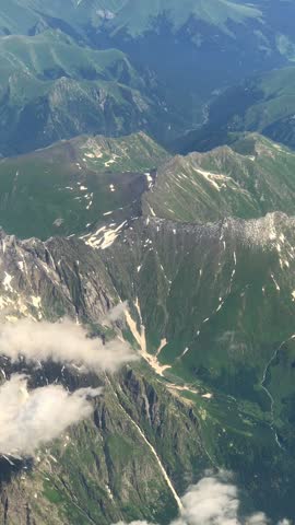 Soar above breathtaking mountain peaks with this stunning vertical drone footage captured in ultra-high definition. Perfect for travel vlogs, meditation backgrounds, and scenic presentations