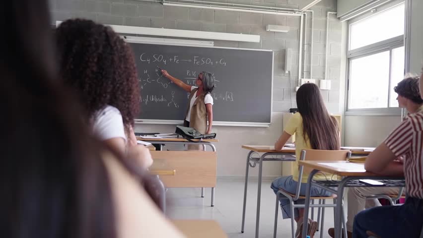 Teacher Explaining Chemistry Formulas to Students in a Classroom Setting at university school. Video with copy space. - Powered by Shutterstock - Get 15% off with code: PIKWIZARD15